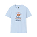 A light blue short-sleeve crewneck t-shirt featuring a graphic on the chest with a coffee cup, a heart-shaped steam swirl, and the text 'Coffee, Chaos & Jesus' in navy and orange lettering.
