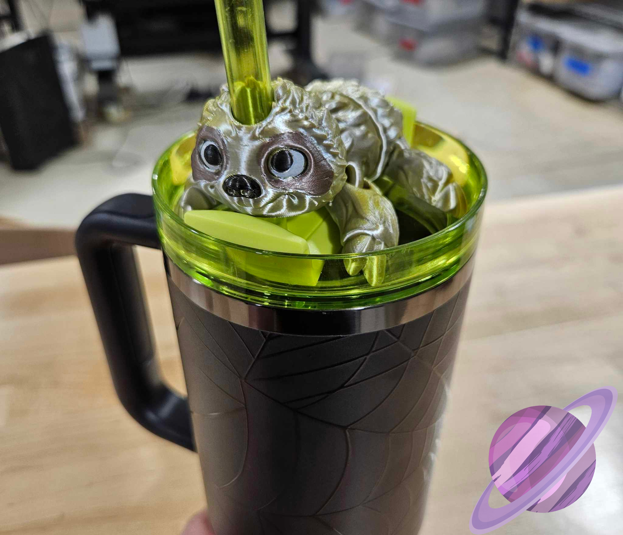 Green mug with a dragon-shaped object inside, on a wooden surface.