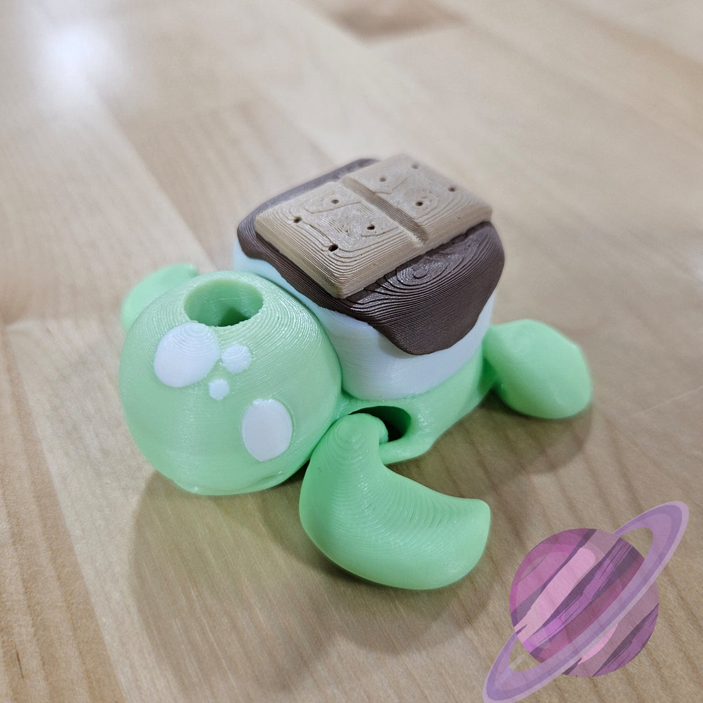 Green toy turtle with a brown object on top, on a wooden surface