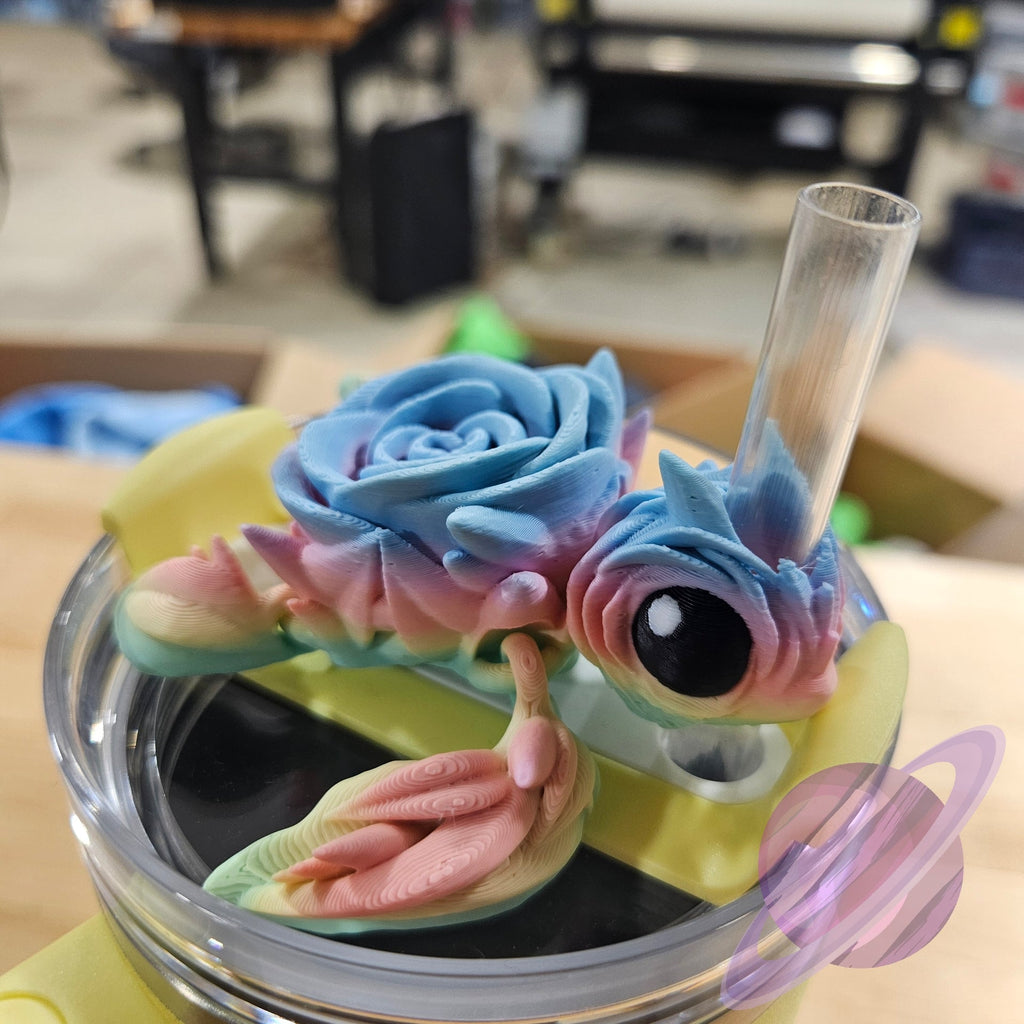 Colorful dragon-shaped straw with a clear lid on a wooden surface