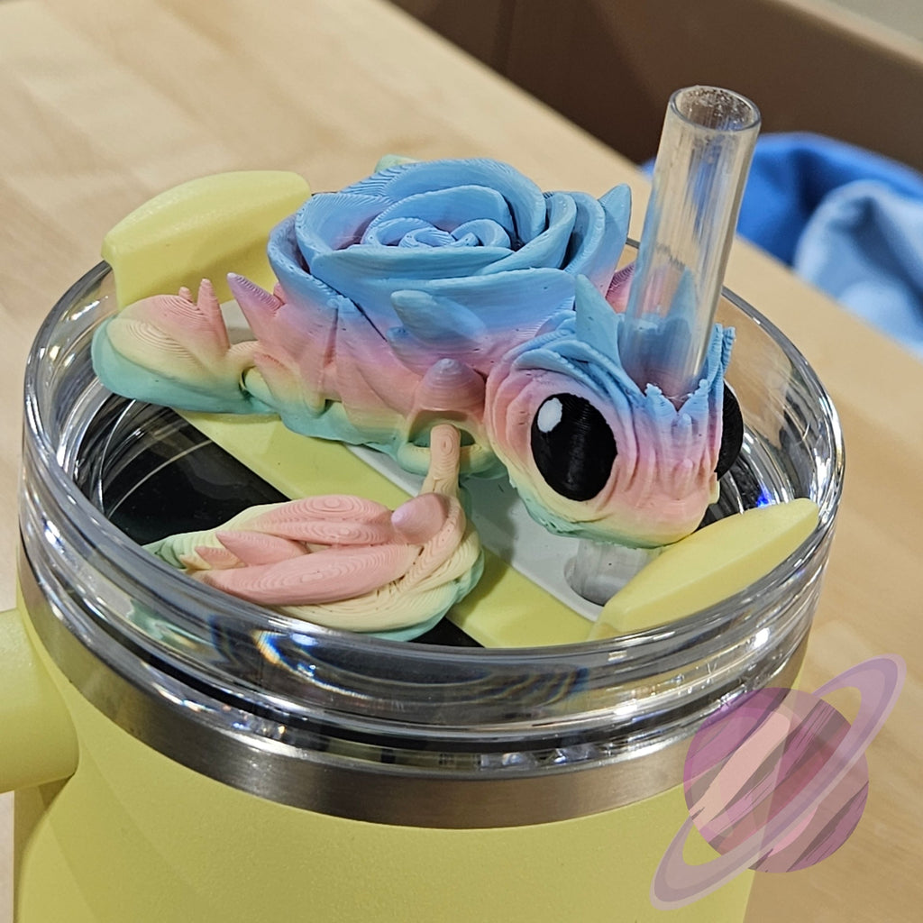 Colorful dragon-shaped straw lid on a clear cup with a yellow base.