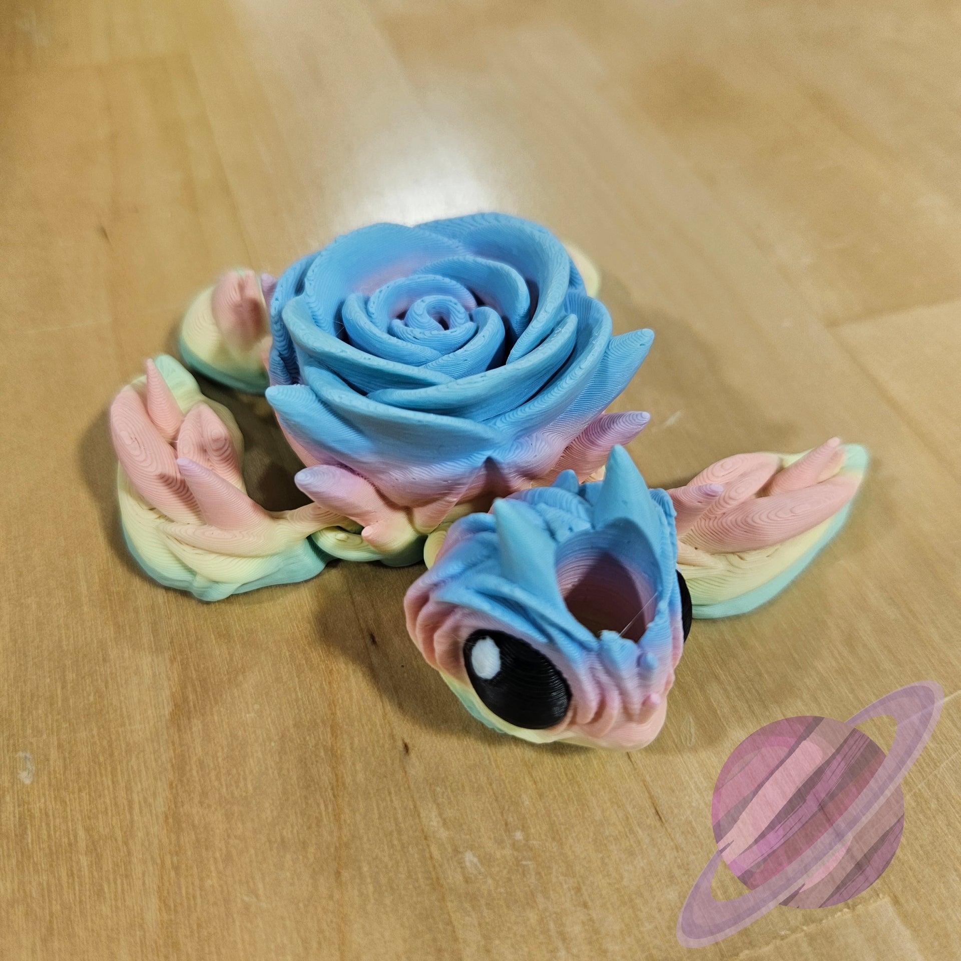 Colorful dragon toy with a rose-like head on a wooden surface