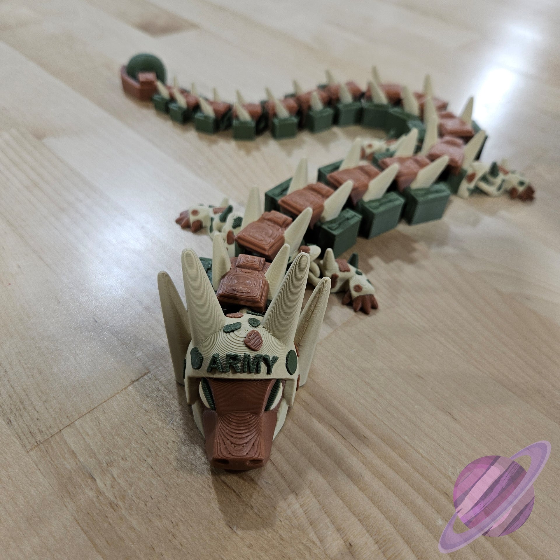 Toy dragon with 'ARMY' on its head on a wooden floor