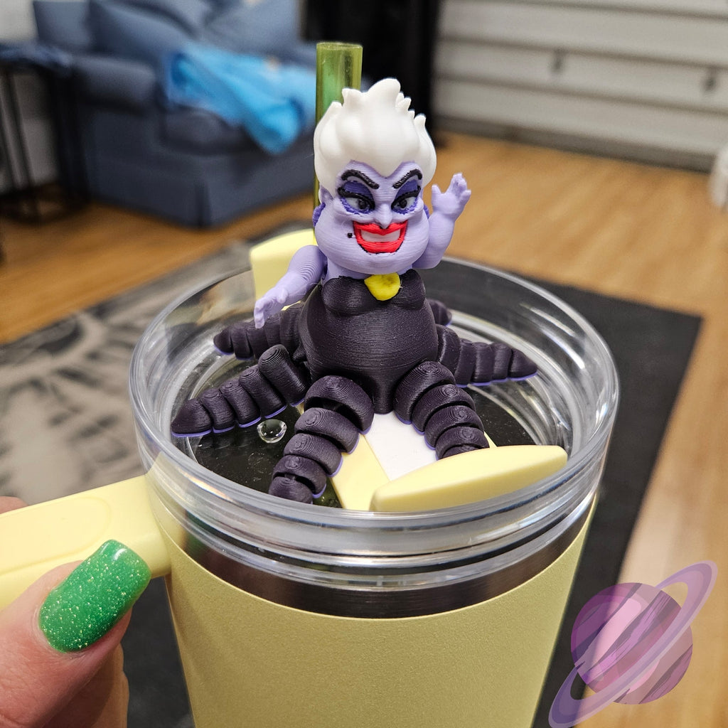 Toy figure of a character with purple hair and black outfit on top of a yellow cup.