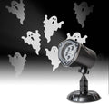 Halloween projector with ghost silhouettes on a black background