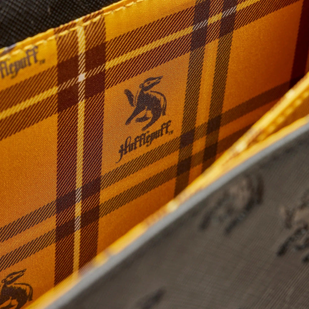 Close-up of a plaid fabric with 'Hufflepuff' branding and logo.