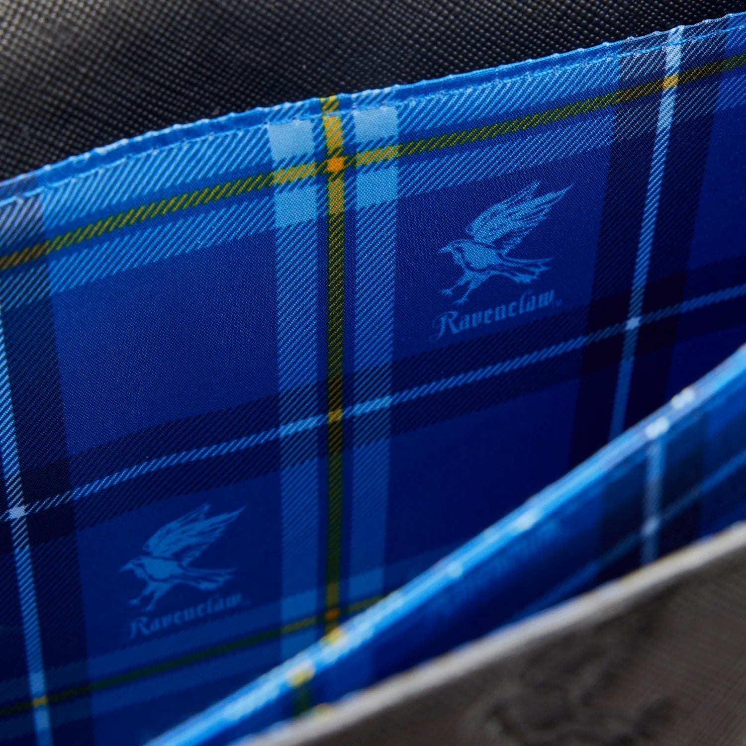 Blue plaid fabric with a logo on a black background