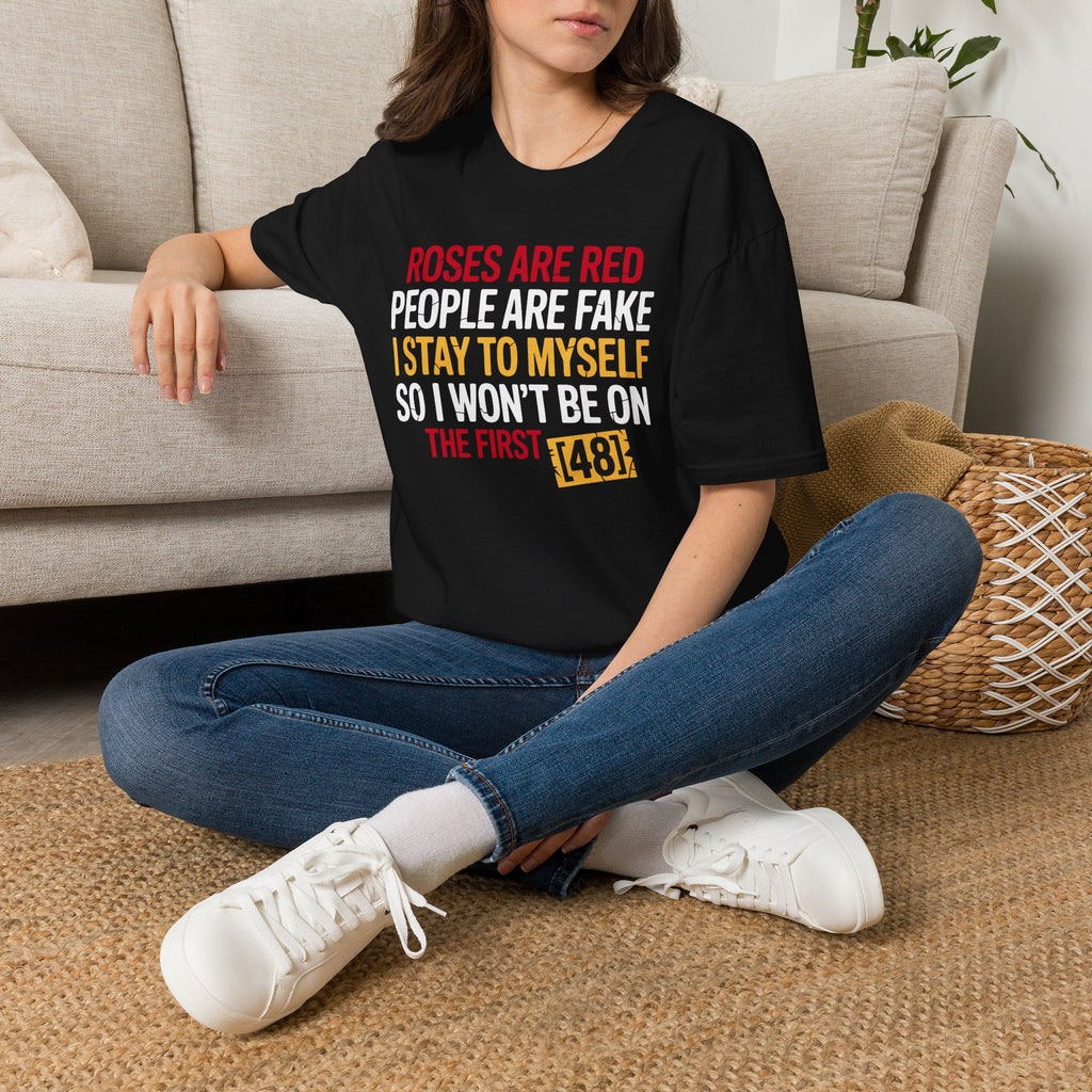 Person wearing a black t-shirt with colorful text in a living room.