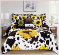 A bed dressed in a cow-print bedding set with large yellow sunflower motifs, including a comforter, matching pillow shams, and a decorative throw pillow, shown in a styled bedroom setting.