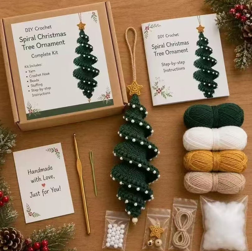 DIY crochet spiral Christmas tree ornament kit laid out on a wooden surface with its box, instructions card, yarn balls, crochet hook, star, beads, cord, and finished ornament.