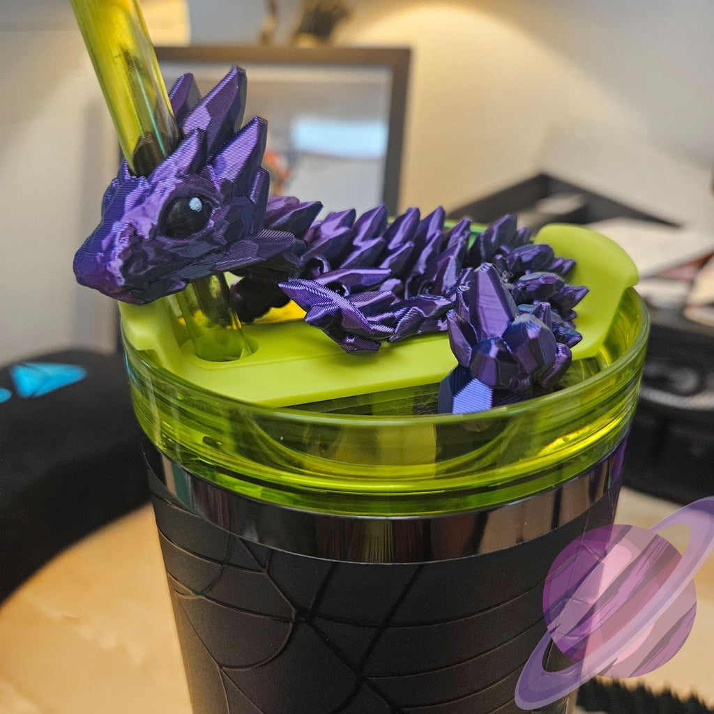 Green tumbler with purple dragon design on a desk