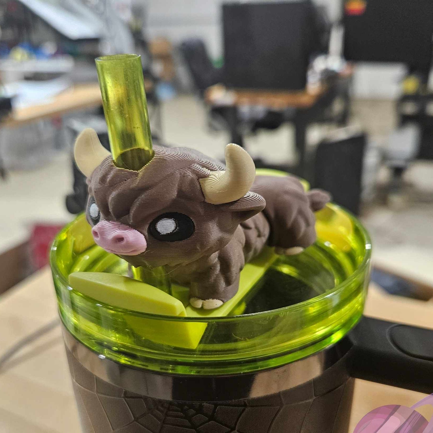 Small figurine of a creature with horns inside a green container on a blurred background