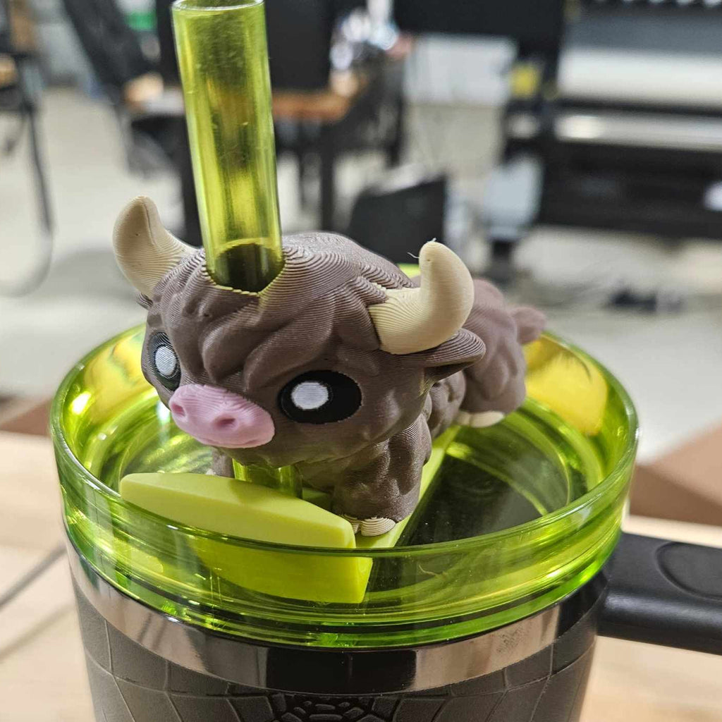 Small figurine of a creature with horns inside a green tumbler.
