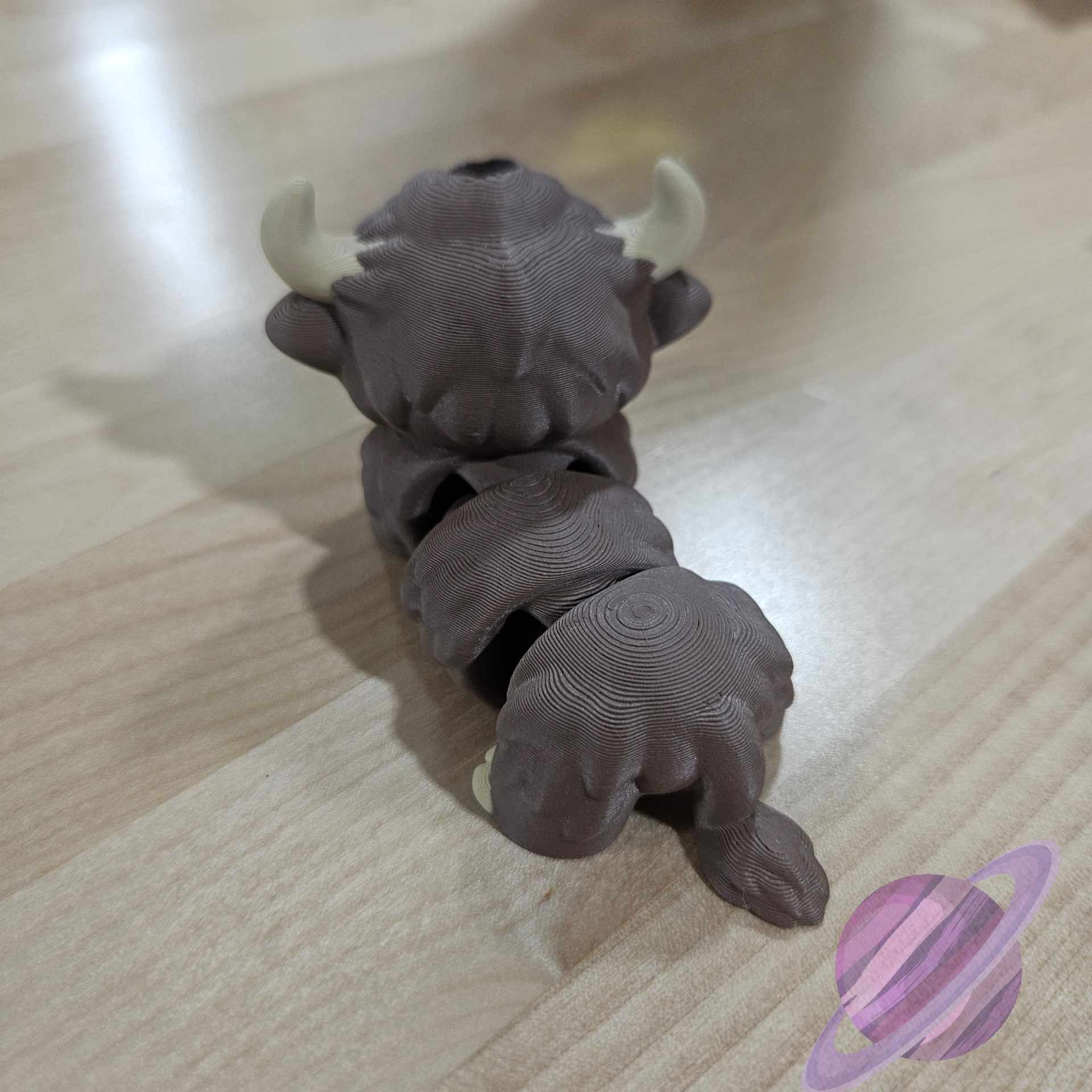 Gray hair tie with white horns on a wooden surface