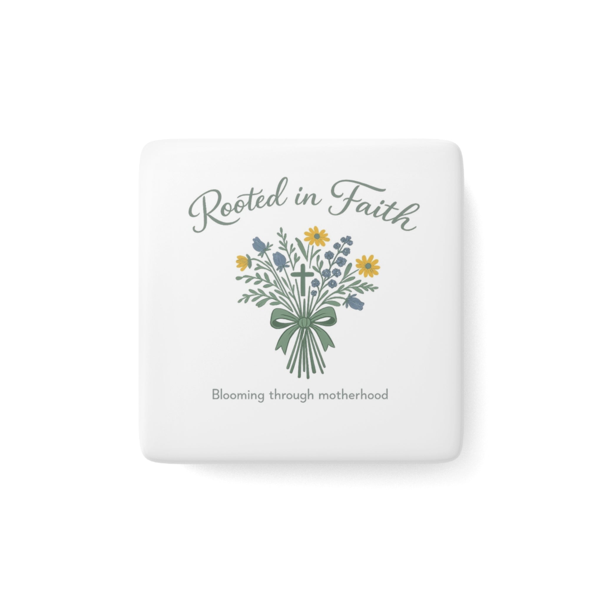A square white ceramic coaster with rounded corners featuring a floral bouquet illustration and the text 'Rooted in Faith' and 'Blooming through motherhood'.