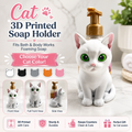 A 3D printed white cat-shaped soap holder with a gold pump dispenser, shown on a bathroom counter with text overlays and color options for the cat design.