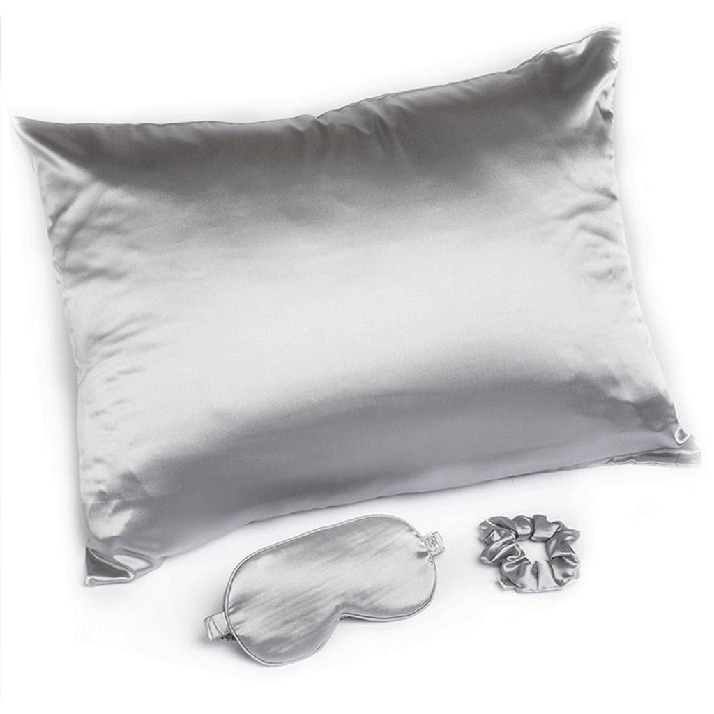 Silver satin pillow, eye mask, and scrunchie on a white background
