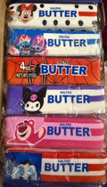 A stack of six packaged Salted Butter elbow-length socks in various colorful cartoon designs, sealed in clear plastic packaging and placed inside a cardboard box.