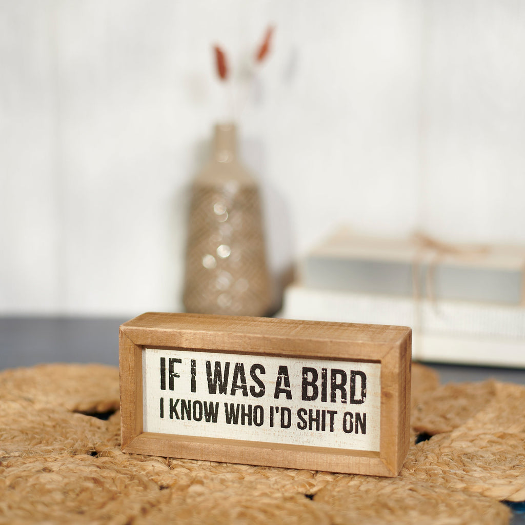 Wooden sign with humorous text on a textured surface