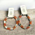 stretch bracelets with bright orange and black beads and white and black skulls