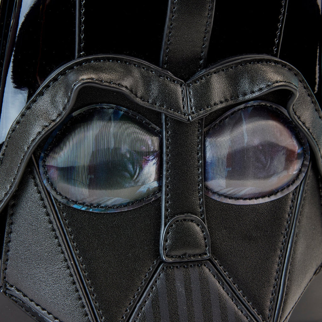 Close-up of a dark mask with detailed design and reflective surface.