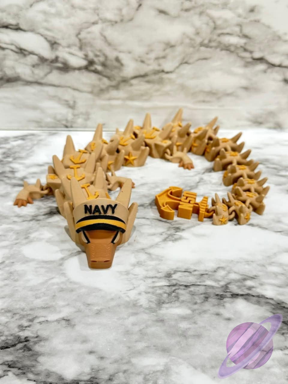 Toy dragon with 'Navy' text on a marble surface